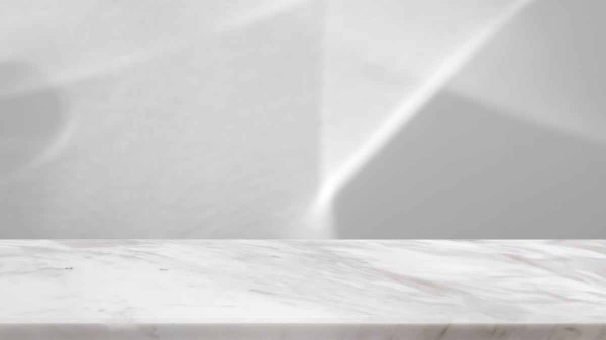 Marble table top with abstract shadow drop on white wall background for mockup product display