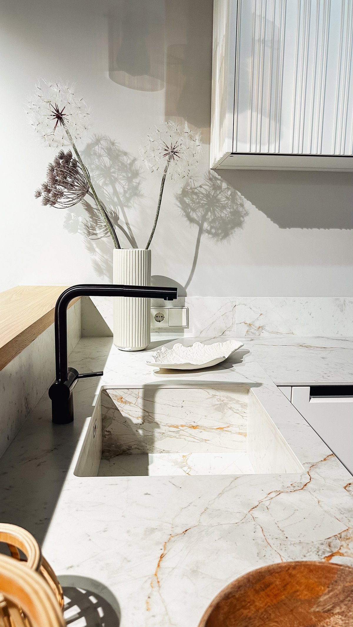 Contemporary kitchen with a freshly sealed marble countertop and black faucet
